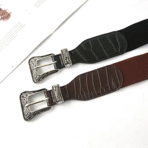 Dettagli di fibbie vintage incise su cinture elastiche nere e marroni da donna