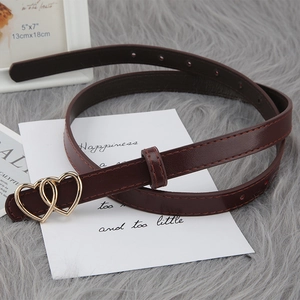 Slim dark brown leather belt with gold double heart buckle for women on soft white background