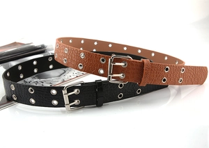 Close-up of punk style double-eyelet belts with stone texture and silver buckle