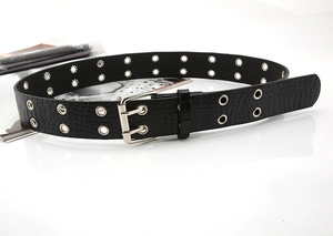 Detail of black faux leather belt with crocodile texture and double row metal eyelets