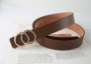 Gros plan détaillé de la ceinture en cuir marron avec boucle dorée à double anneau