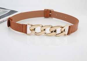 Détail de ceinture en cuir gaufré crocodile avec chaîne en métal doré épais