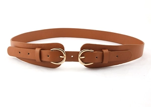Détail d'une ceinture marron en similicuir avec une boucle dorée élégante à double anneau
