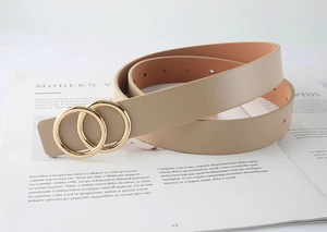 Détail de la ceinture en cuir beige avec boucle à double anneau doré sur magazine