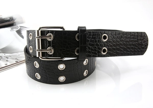 Detail view of black crocodile pattern leather belt with double grommets and silver buckle