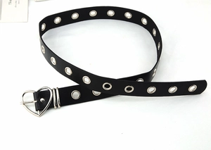 Detail of black punk belt featuring silver metal eyelets and a heart-shaped metal buckle