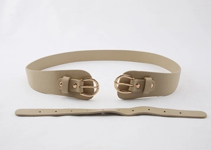 Détail de la ceinture corset beige avec boucles métalliques double D dorées polies en cuir PU
