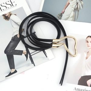 Minimalist black thin leather belt for women featuring a gold heart-shaped buckle on magazines