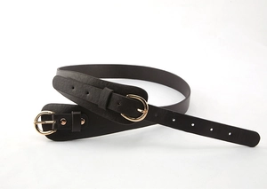 Détail de ceinture noire avec deux boucles dorées et texture cuir litchi grainé