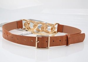 Détail de ceinture marron à motif crocodile avec boucle dorée et chaînes épaisses
