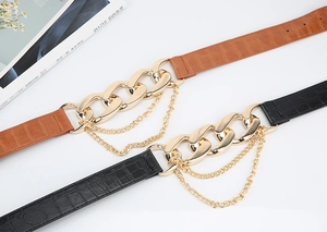 Détail de ceintures en cuir croco avec boucle dorée et chaînes pour robes