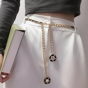 Detail der goldenen Metall-Ketten-Gürtel mit schwarzem Leder und Perlenanhängern