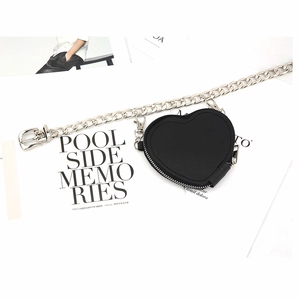 Mini borsa a cuore nera con cintura a catena punk in metallo argento su sfondo di rivista