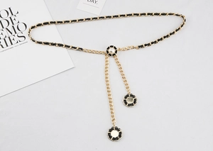 Makroaufnahme einer Goldkette mit schwarzem Leder und einem zentralen Perlanhänger-Detail