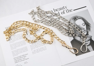 Detail of chunky gold and silver metal hip-hop chains with textured lobster clasps