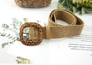 Detail of bohemian straw woven belt featuring a leopard print square buckle and khaki texture