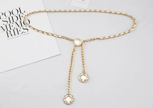 Detailansicht der goldenen Kettengürtel mit weißem Leder und Blumenanhängern für Damen