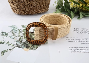 Detail view of a bohemian straw woven belt featuring a stylish leopard print square buckle
