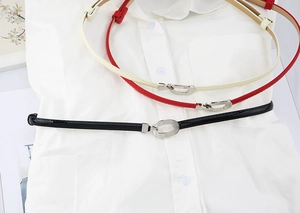 Détail de ceintures fines pour femmes en noir, rouge et blanc avec boucles ovales
