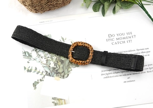 Detail of black woven straw belt with vintage leopard print square buckle on a magazine