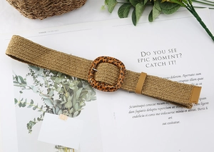 Close-up of woven elastic belt featuring leopard print buckle and leather trim details