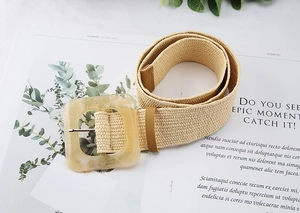 Detail of a woven straw belt with an amber resin square buckle on a magazine