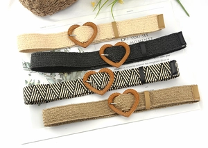 Detail of four straw woven belts in various colors featuring heart-shaped wooden buckles