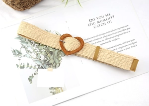 Close-up of bohemian straw belt featuring a unique heart-shaped buckle on a magazine