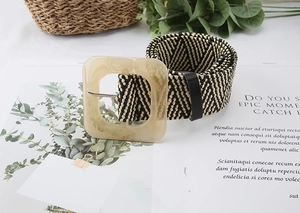 Detail view of woven straw belt with chevron pattern and square marble resin buckle