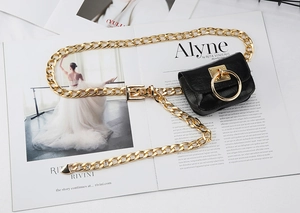 Dettaglio mini borsa da cintura nera con anello dorato e cintura a catena grossa