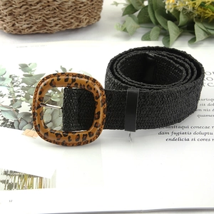 Women's woven straw belt in black with a retro leopard print buckle on a magazine background