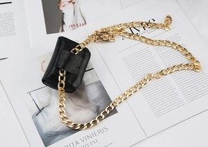 Dettaglio della catena in metallo dorato con mini borsa in pelle nera decorativa