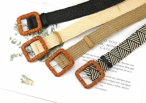 Flat lay of woven waist belts in four colors with large square wood-style buckles
