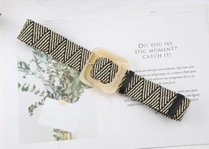 Detail view of woven straw belt with geometric pattern and amber square resin buckle