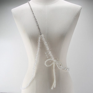 Detail of elegant pearl and crystal body chain with a decorative layered bow