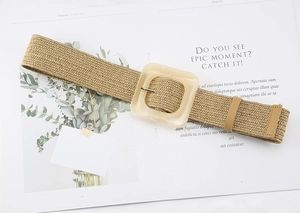Detailed view of woven straw belt texture with cream square resin buckle on magazine