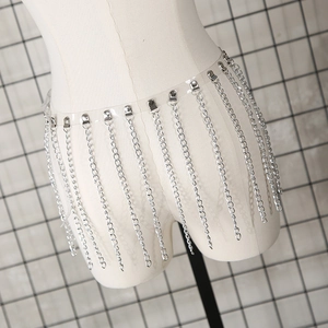 Détail macro de la ceinture en PVC transparent avec chaînes à franges métalliques