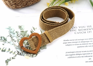 Detail view of khaki woven belt with unique heart-shaped buckle and vintage texture
