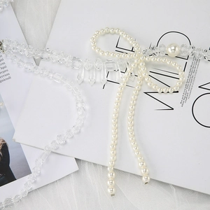 Detailed view of elegant crystal bead vest chain featuring a pearl bow and long tassels
