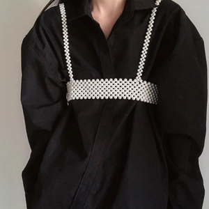 Exquisite handmade pearl body chain jewelry worn over a black shirt for a luxury style