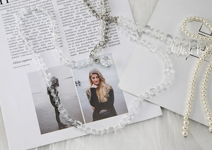 Detail of faceted crystal beads and pearl strap with silver lobster clasp on a magazine