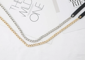 Dettaglio di cinture a catena in metallo hip hop in oro e argento con inserti pelle