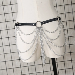 Détail d'une ceinture en similicuir punk avec plusieurs chaînes de corps en métal argenté
