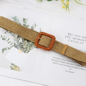 Bohemian khaki woven straw belt with an orange square buckle on a magazine background