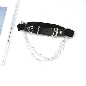 Detail of a punk heart leather leg garter with double silver chains and metal buckle