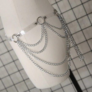 Détail de ceinture en PVC transparent avec chaînes argentées multicouches et anneaux