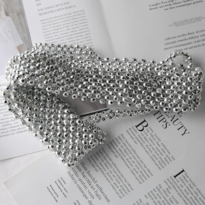 Detailed macro shot of silver multi-layered beaded vest showing metallic luster and texture