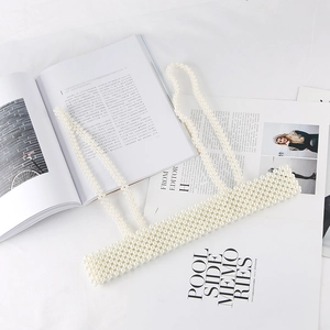 Close-up of elegant white pearl woven vest featuring high-gloss beads and straps