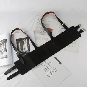 Détail d'un corset en cuir noir style punk avec boucles argentées sur tissu blanc