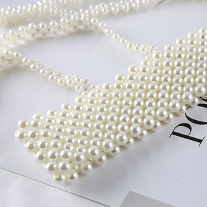 Detailed view of white faux pearl woven strap camisole with dense beaded texture